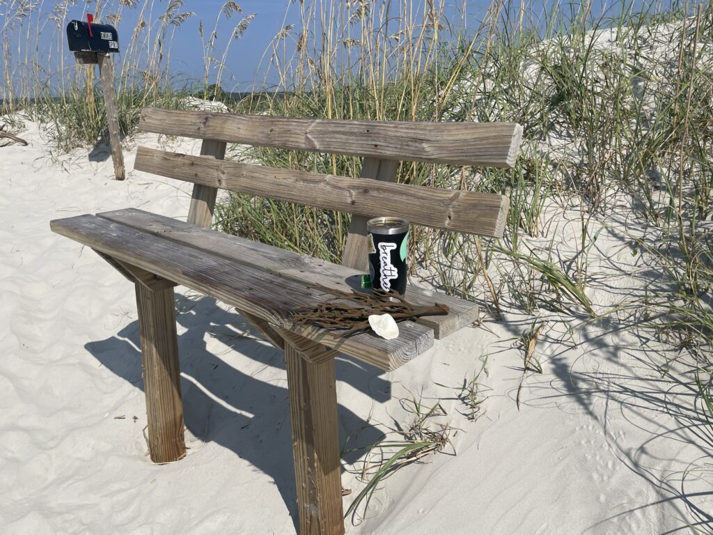 Wooden bench by a mailbox at the beach