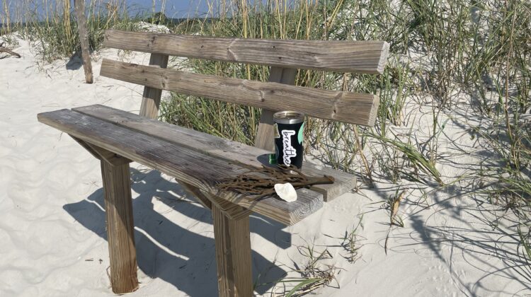 Wooden bench by a mailbox at the beach