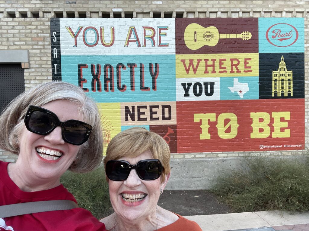 Emily and mom in front of a painted sign