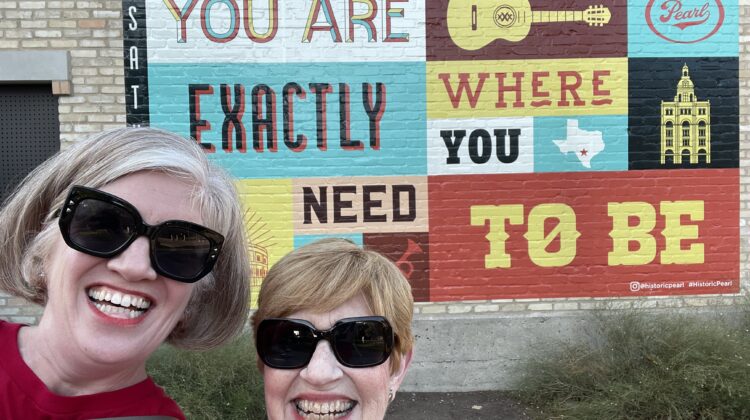 Emily and mom in front of a painted sign